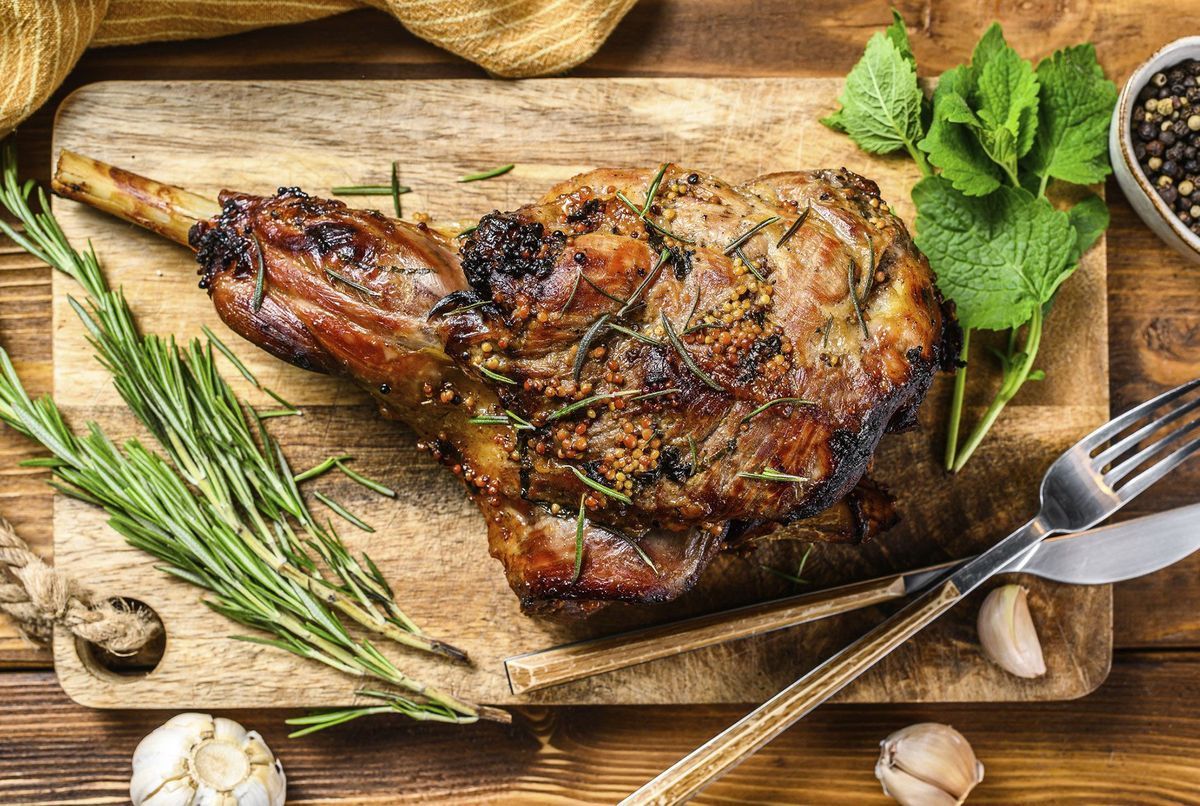 Gigot d'agneau rôti accompagné d'un verre de vin rouge